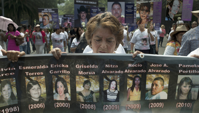 A woman holds a placard with picture of