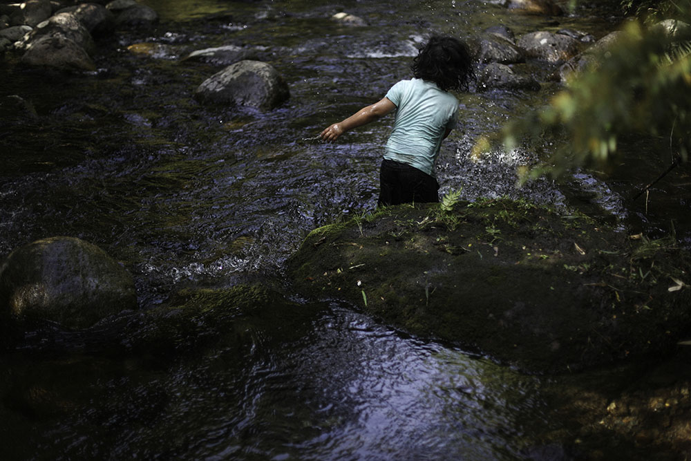 Hijo de Ruben Collio juega en un pequeño rio que pasa bajo su terreno en la localidad de Tranguil.©Ruta35r/Cristobal Saavedra