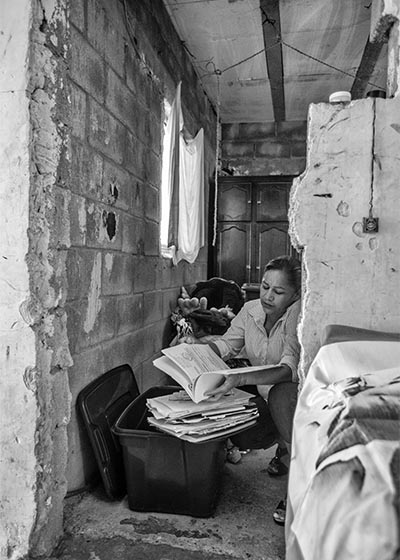 Marcela busca en una caja la libreta de su hijo Cosme, donde solía escribir pensamientos y citas bíblicas.